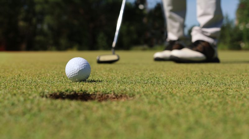 A person is practicing the timing of their golf swing in cold weather.